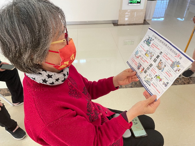 图四:老人查看反诈骗宣传资料.jpg